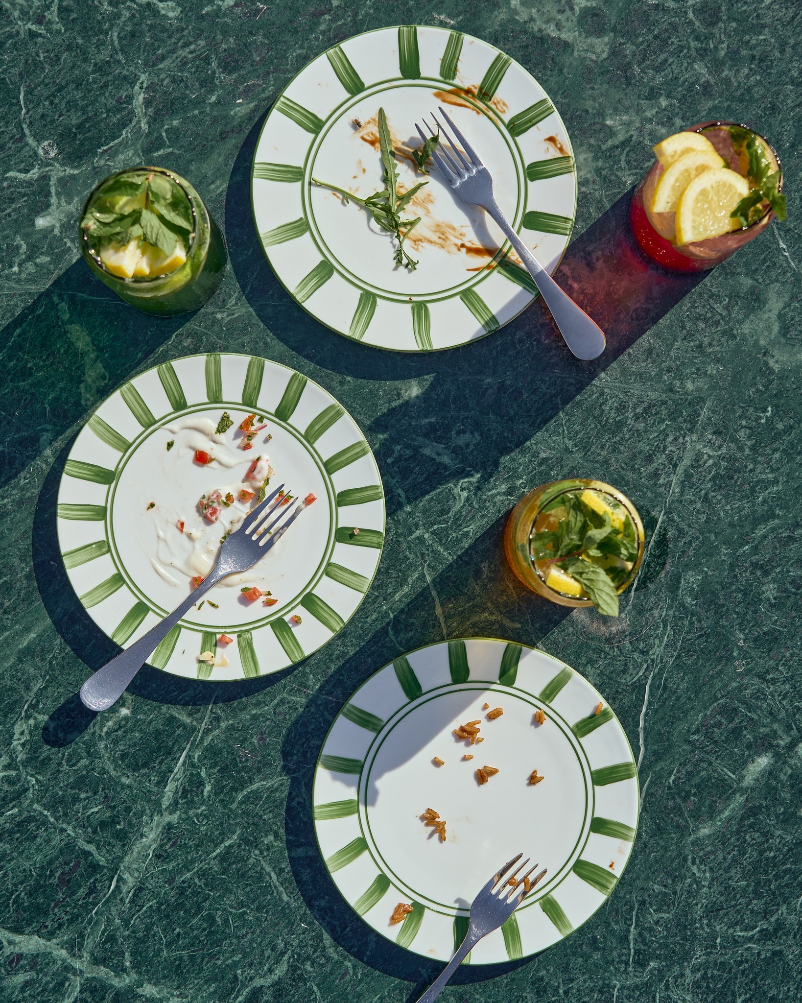 Finished plates and mojitos on green marble
